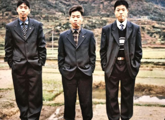 FB体育 FB体育平台1995年四川从东莞鞋厂回家过春节的年轻人叼着烟穿不合身西装(图1)
